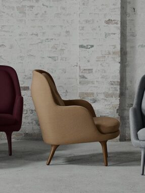 Tan upholstered lounge chair against white brick